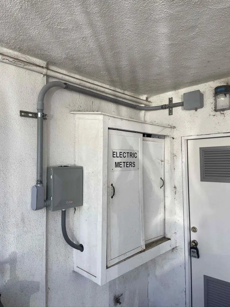 Electric meter enclosure and conduit in a building passage