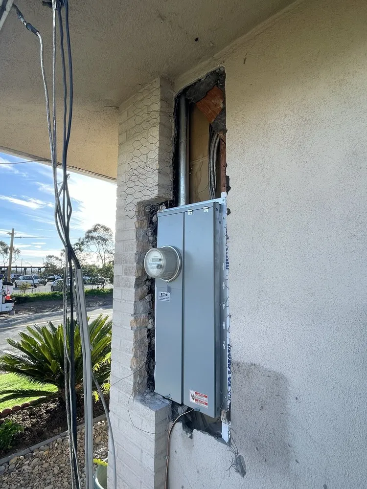 New electrical panel and meter installed on a stucco wall