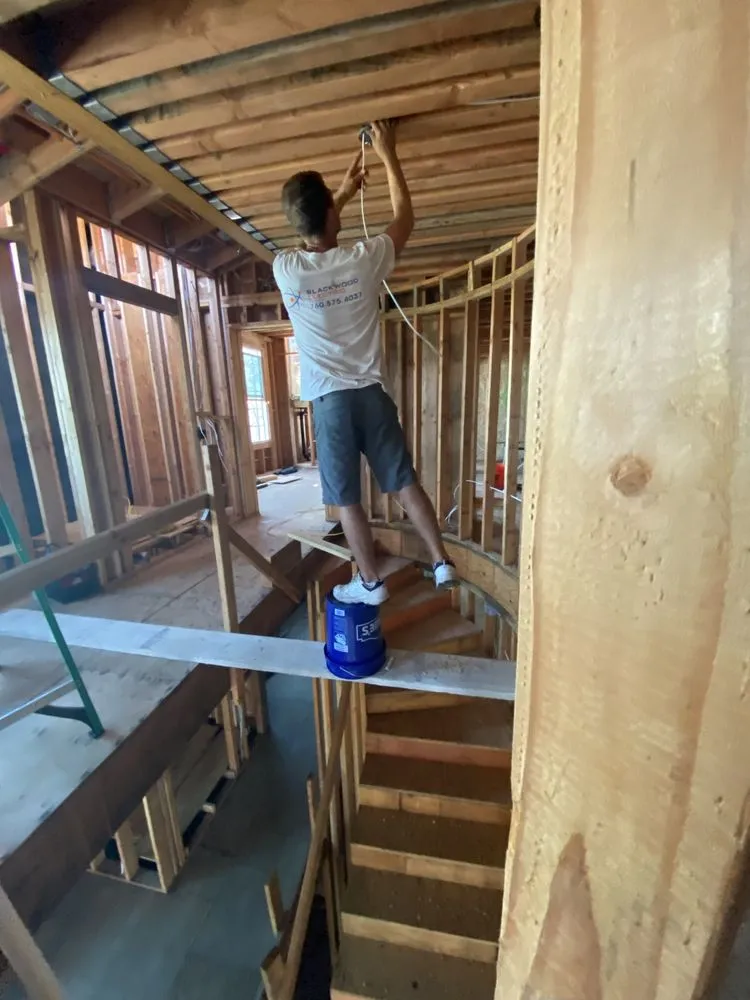 Travis wiring a framed new-construction home