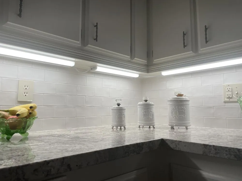 Under-cabinet LED lighting over a white kitchen counter